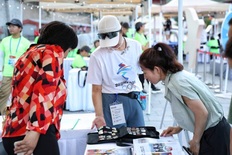 8月16日，居庸关长城，市民观看奥运纪念章。新京报记者 陶冉 摄